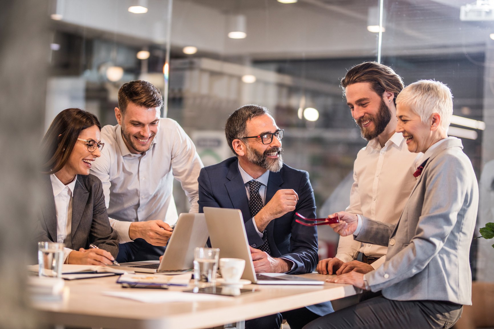 Happy business team communicating while working on computers in the office.